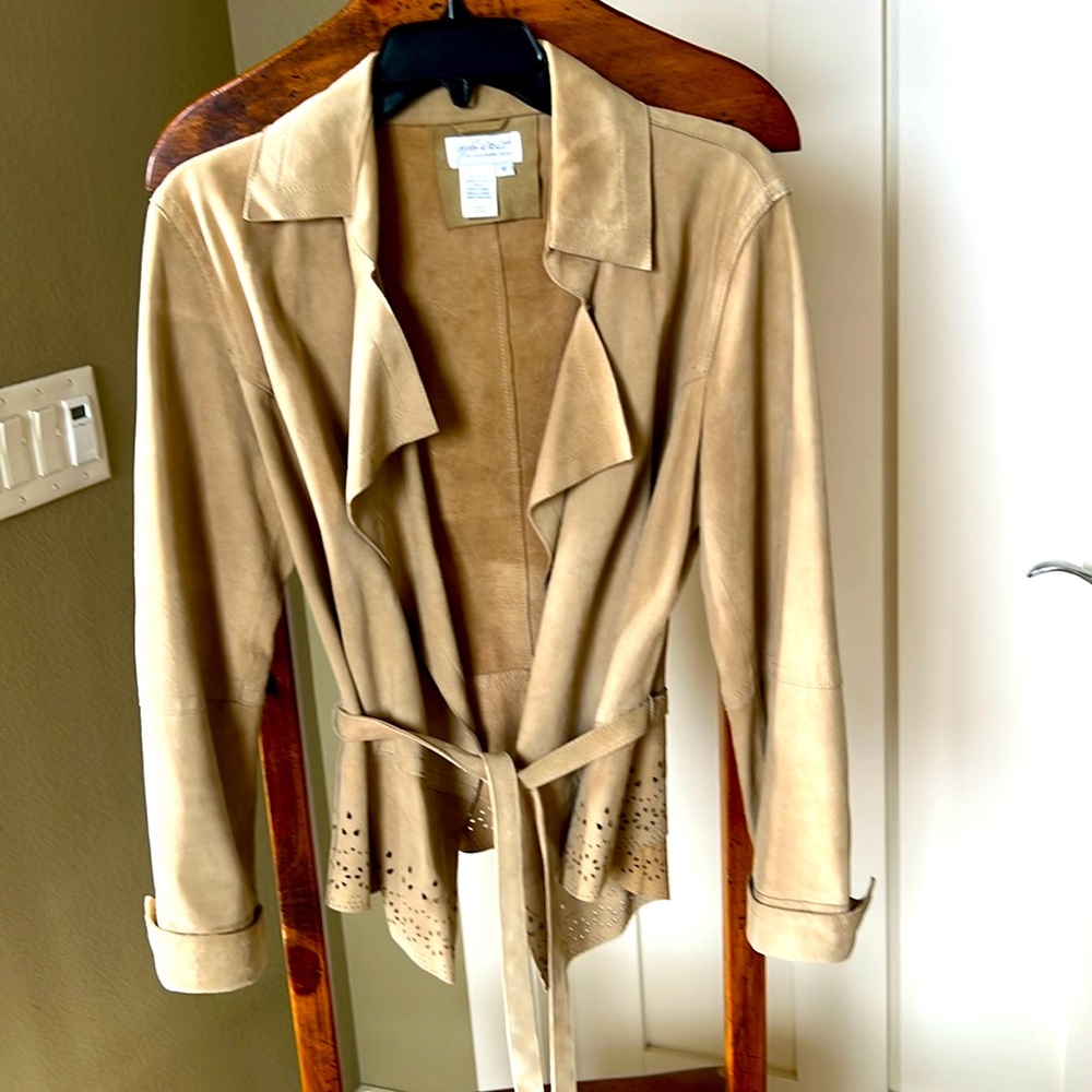 Leather jacket with detailed cutouts and belt.